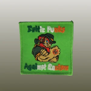Ein Patch, auf dem ein Ire mit Pfeife mit seinem Bizeps flext. Der Stick besagt: Celtic Punks Against Racism.