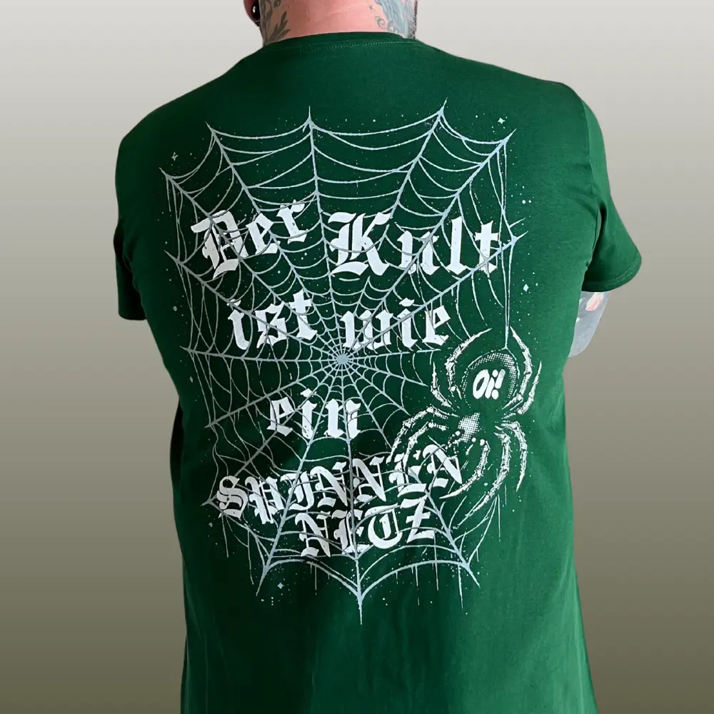 Rückseite des grünen Oisturm-Asozial-Shirts mit großem Spinnennetz und Schritzug "Der Kult ist wie ein Spinnennetz" in Weiß.